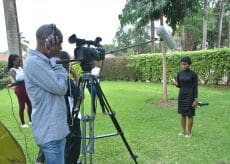 Woman being interviewed by journalists at Makerere