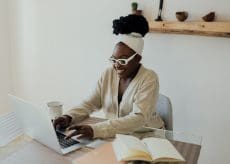 science journalism story grant blog image - woman sitting at desk typing on computer